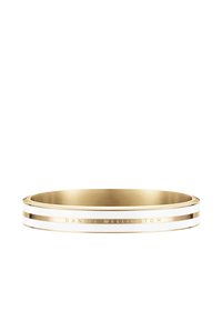 Zelta aproce ar divām baltām svītrām un iegravētu tekstu "DANIEL WELLINGTON." Gluda tekstūra un noapaļota forma. Minimālisma stils.