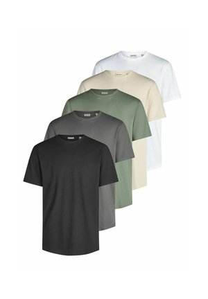 Mann trägt ein schlichtes schwarzes Kurzarm-T-Shirt und hellblaue Jeans, steht vor einem schlichten hellen Hintergrund.