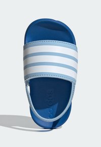 Blue slide sandals featuring a wide strap with white and light blue stripes. Textured sole with embossed logo. Lightweight material.