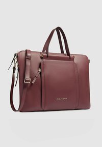 Valigetta in pelle bordeaux con due manici superiori e tracolla removibile, dotata di una tasca frontale e dettagli in metallo color oro.