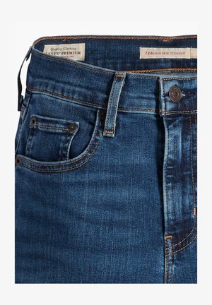 Jeans in denim a gamba dritta alta in blu scuro con cuciture dorate, chiusura con bottone in metallo e una piccola tasca per le monete frontale.