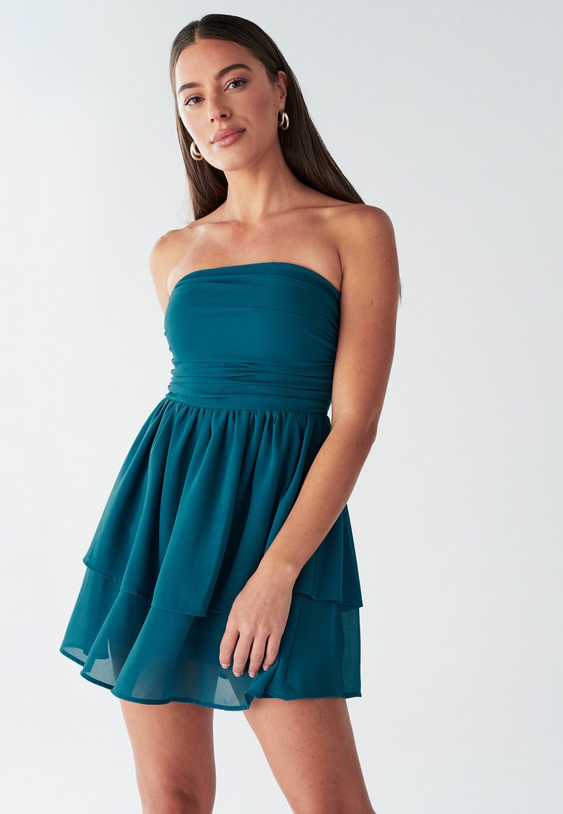 Teal strapless jurk met gelaagde rok, gemaakt van lichtgewicht stof. Heeft een aansluitende lijfje met plooien en een zachte, vloeiende textuur.
