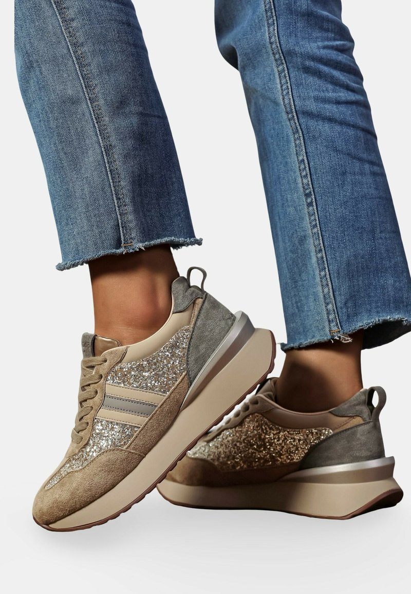 Baskets avec une palette de couleurs beige et grise, présentant un dessus scintillant, des accents en daim et une semelle épaisse avec une finition texturée.