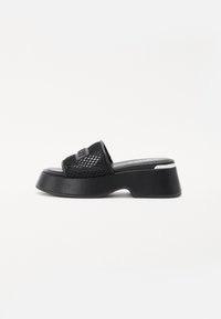 Black platform slide sandal with a textured mesh upper, wide strap, and a sturdy rubber sole. Features a slight heel and smooth footbed.