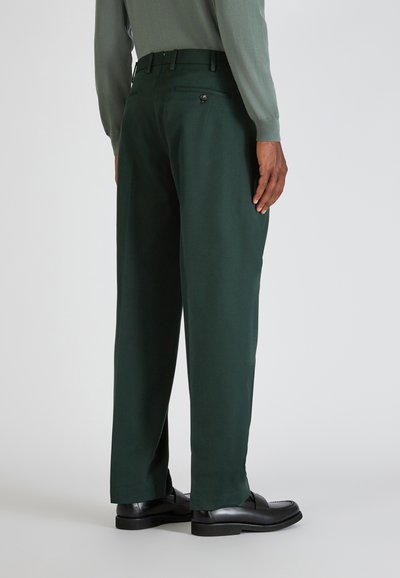 Dunkelgrüne Anzughose mit taillierter Passform, glattem Stoff und einer einzigen Gesäßtasche mit Knopfverschluss. Flacher Vorderteil.
