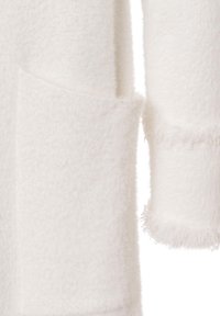 Weißer Fleece-Oberteil mit einer einzigen Paspeltasche, ausgestattet mit einer strukturierten Oberfläche und fransigen Ärmelabschlüssen. Weiches und leichtes Material.