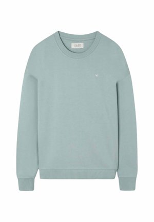 Jersey azul claro de manga larga con cuello redondo, puños y dobladillo acanalados, y pequeño logo blanco bordado en el pecho izquierdo.