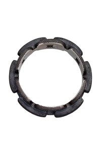 Metallring med en mörk, strukturerad yta som har en serie utskjutande, jämnt fördelade segment. Inuti har den en slät silverfinish.