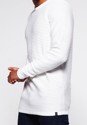 Weißer, langärmeliger, strukturierter Pullover mit horizontalen Rippen. Hat einen runden Halsausschnitt und enganliegende Bündchen. Kleines Logo auf der unteren linken Seite.