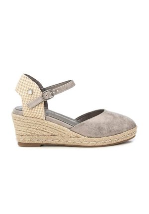 Sandalia cuña de punta cerrada con plataforma de yute trenzado, talón trasero texturizado beige y correa ajustable en el tobillo con hebilla.