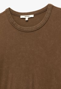 Brun bomulds T-shirt med rund hals. Blød tekstur, enkelt design og synlige sømme omkring halsudskæringen med en mærketiket.