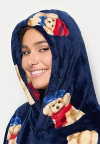 Hanorac din fleece de marine cu modele jucăușe cu ursuleți de pluș, inclusiv eșarfe roșii și pălării albastre, având un finisaj moale și texturat.