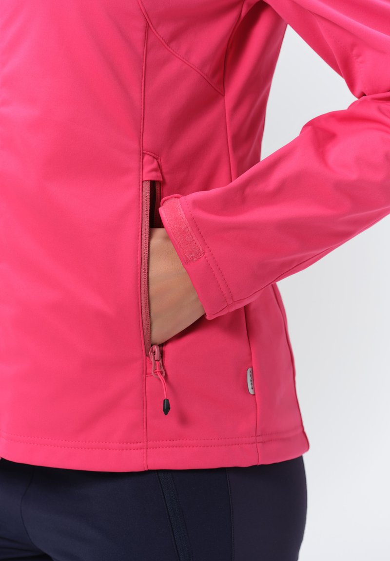 Dopasowana różowa kurtka z miękkiego, gładkiego materiału; ma kieszeń na zamek błyskawiczny oraz regulowane mankiety z rzepem.