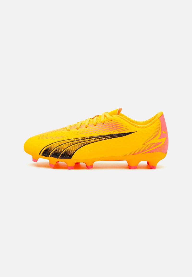 Botín de fútbol amarillo con acentos negros y un diseño en degradado. Presenta una forma aerodinámica, superficie texturizada y tacos con punta rosa.