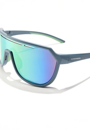 Zonnebril met een blauw kunststof montuur en grote, reflecterende, gradient lenzen met tinten groen en paars; minimalistische designelementen.