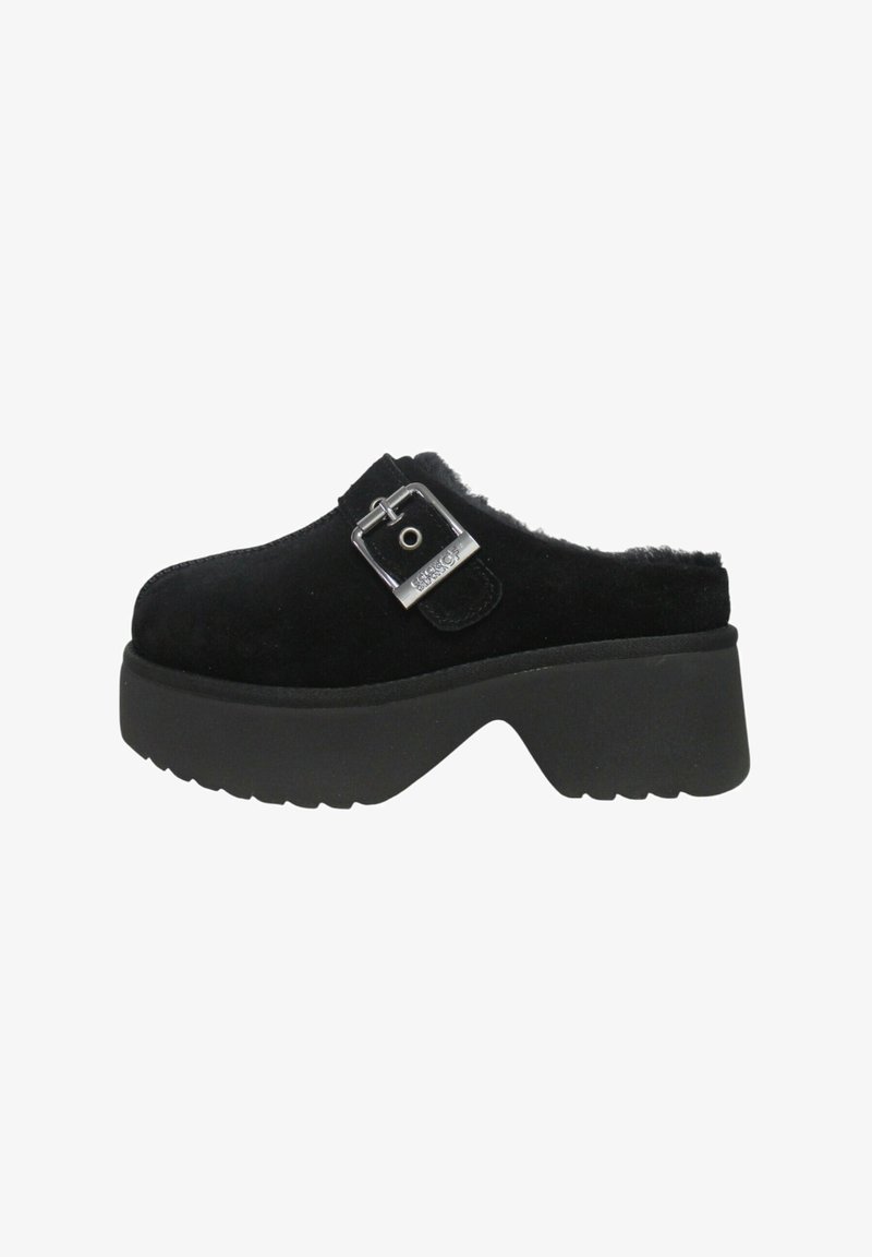 Zoccoli in camoscio nero con fibbia, caratterizzati da una suola spessa nera e un bordo soffice lungo l'apertura per aggiungere texture.