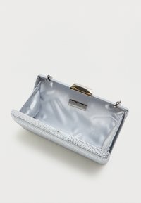 Světle modrá kabelka typu clutch s texturovaným povrchem, kovovým zavíráním a saténově podšívkou. Na okraji má dekorativní ozdoby.