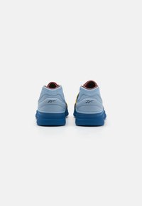 Blue sneakers with a textured upper, contrasting yellow and red accents, padded collar, and a thick rubber sole. Two pairs shown from the back.