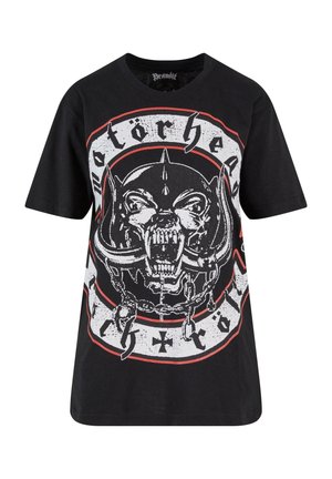 Melna t-kreklu ar apaļu kaklu, kura priekšpusē ir izcili izdrukāts pelēks un balts attēls ar snarling dzīvnieku, kas ir ieslēgts ķēdēs, un uzraksts "Motorhead" lielos burtos.