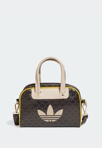 Hnědá a béžová taška Adidas se vzorem loga trefoil, žlutým obšitím, béžovými uchy a odnímatelným ramenním popruhem.