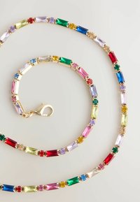 Kolorowy naszyjnik z kamieni szlachetnych, z elementami w kolorze złotym. Kamienie w kształcie prostokątnym i okrągłym w kolorach czerwonym, zielonym, niebieskim, różowym i żółtym.