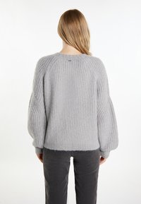 Világosszürke kötött pulóver texturált bordázott mintával, raglán ujjal és enyhén cropped alsó résszel. Puha, kényelmes anyag.