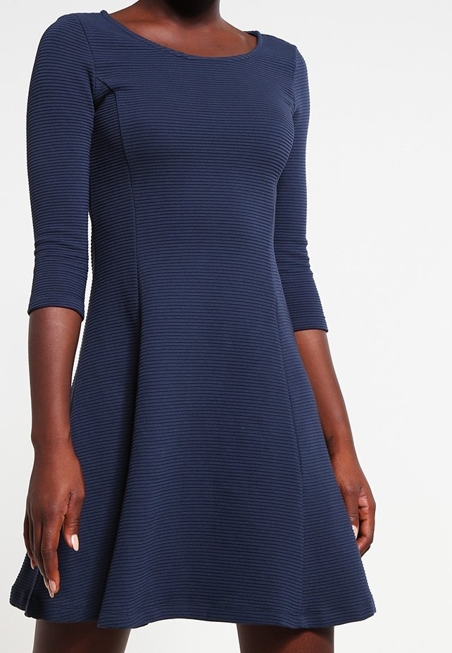 Robe bleu marine côtelée avec un col rond et des manches trois-quarts, évasée à la taille pour un ajustement décontracté.