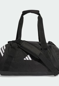 Bolsa de lona negra con diseño de tres rayas blancas, tela resistente, correas ajustables y asas superiores para opciones versátiles de transporte.