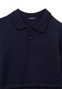 Polo in maglina blu navy con colletto a scallop, patta con quattro bottoni e orlo a costine. Texture morbida e design classico e semplice.