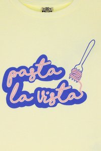 Lys gul hettegenser med teksten "pasta la vista" i rosa og blå skrift, med en gaffel og pasta-grafikk på høyre side.