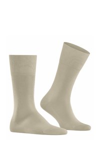 Calzini in cotone beige con polsini a costine e superficie liscia. Lunghezza classica senza motivi o dettagli.
