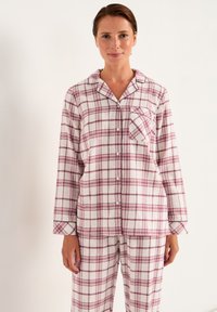 Geruit pyjama set in zachte stof met witte, roze en bordeauxrode strepen. Langsleeve top met een borstzak en knopen.