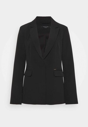 Blazer nero da donna su misura con rever a lancia, maniche lunghe, tasche frontali con patta e design monopetto su sfondo bianco.