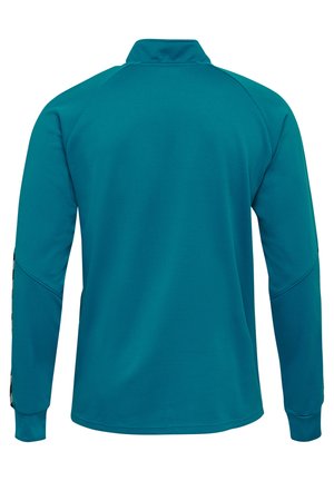 Teal lange mouw sportshirt van een gestructureerde stof, met een verhoogde kraag en geribde manchetten. Voorzien van naaddetails langs de schouders.