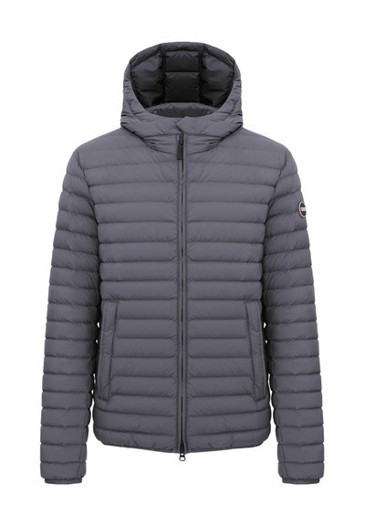 Veste matelassée grise avec capuche, fermeture éclair frontale, deux poches latérales et un petit logo rond sur la manche gauche.