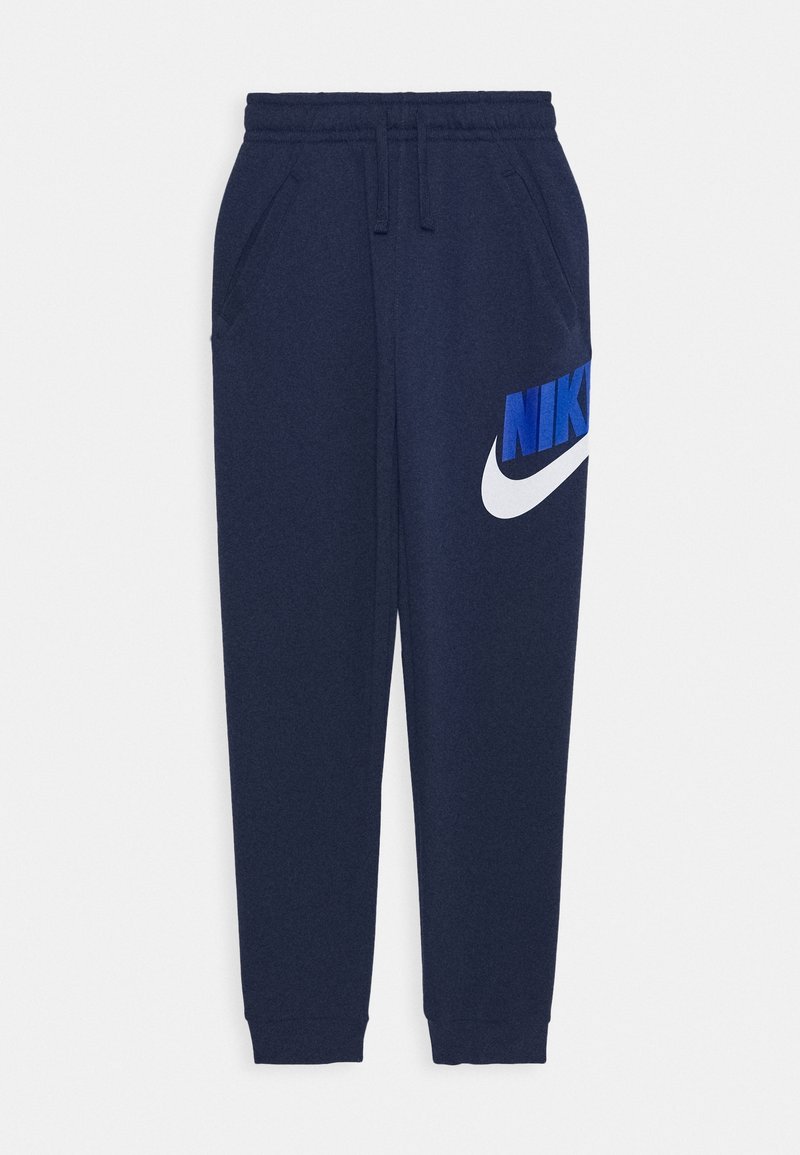 Pantaloni della tuta blu navy con vita elasticizzata, tasche laterali e un grande logo Nike blu con uno swoosh bianco sulla coscia sinistra.