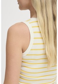 Camiseta sin mangas de canalé blanca con rayas amarillas horizontales, con un escote redondo y un diseño ajustado.