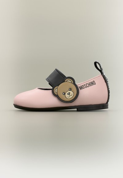 Chaussure Mary Jane rose avec bride noire, décoration d'ours en peluche sur le côté, semelle noire et logo Moschino sur la languette du talon et sur le côté.