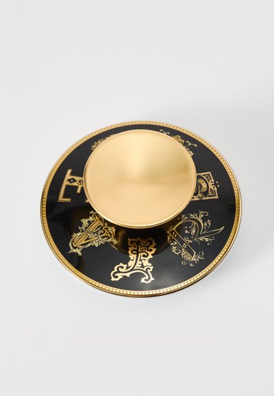 Czarna ceramiczna podstawka z złotymi akcentami i misternymi wzorami, z złotą miską w centrum. Całość wykończona na wysoki połysk.