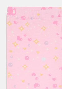 Light pink leggings featuring a playful pattern of hearts, stars, and circles in yellow, purple, and blue. Soft, stretchy cotton material.