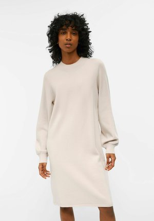 Beige knitted dress with a crew neckline and long, balloon sleeves, featuring a relaxed fit and soft texture, reaching mid-thigh length.