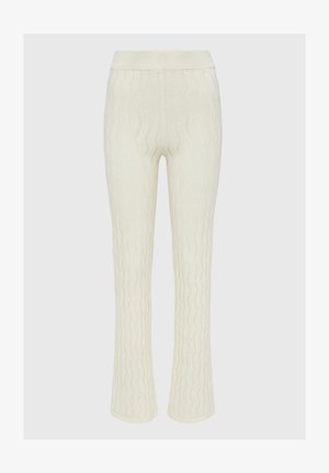 Pantalons blancs en tricot à cable avec une taille côtelée, des jambes évasées et un motif texturé en vagues sur l'ensemble du tissu.