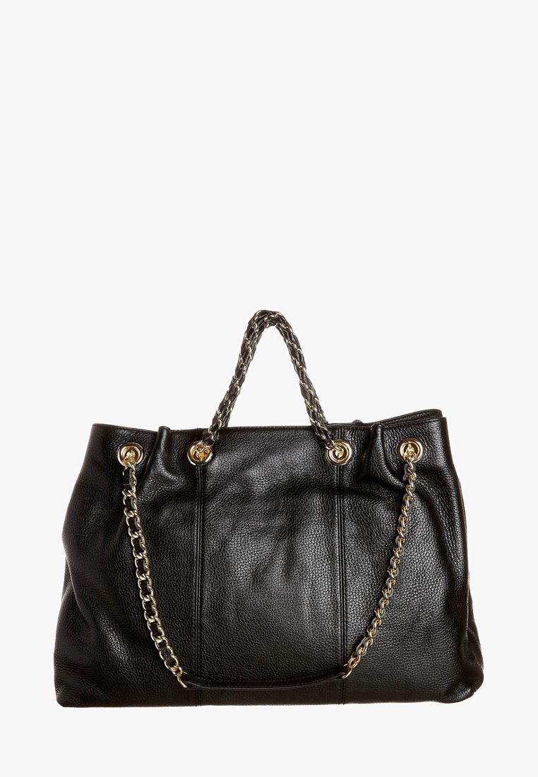 Černá texturovaná kožená kabelka se zlatými řetízkovými uchy a zlatými nýty na bílém pozadí.