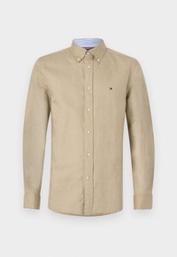Beige overhemdd met een kraag, lange mouwen en een subtiel logo op de linkerkant van de borst. Gemaakt van een lichte stof.