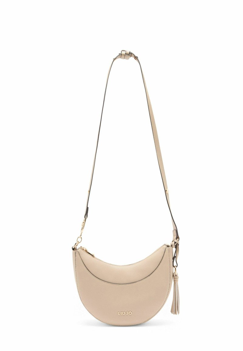 Beige kožená taška přes rameno s křivkovým designem, která má zlatý zip, detail s třásněmi a nastavitelné rameno.