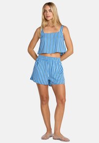 Μπλε και λευκό ριγέ κοντό τοπ με τετράγωνη λαιμόκοψη και ταιριαστό σορτς. Λείο ύφασμα, άνετη εφαρμογή και ελαστική μέση στα σορτς.