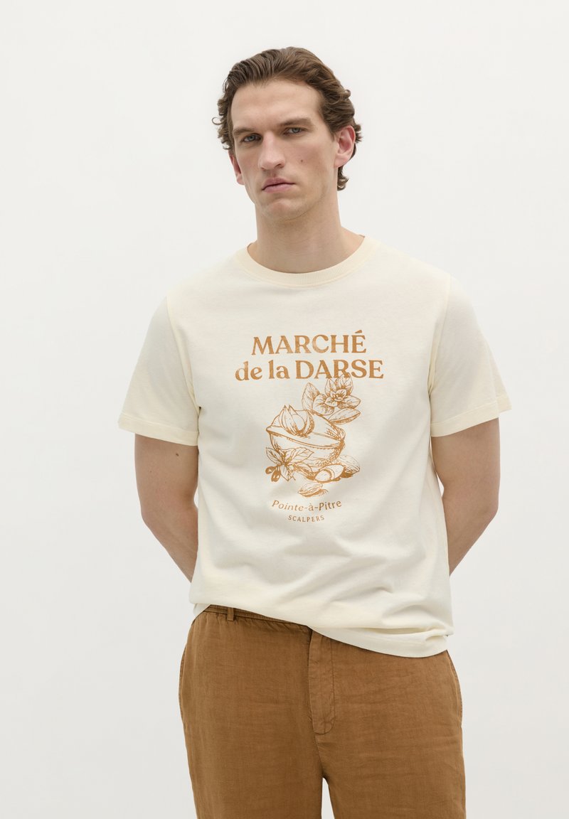 Beige katoenen t-shirt met ronde hals, voorzien van een bruine bloemenprint en de tekst "MARCHÉ de la DARSE, Pointe-à-Pitre, SCALPERS."