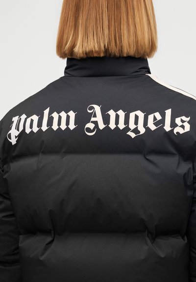 Μαύρο επενδεδυμένο μπουφάν με μεγάλο λευκό κείμενο "palm Angels" στην πλάτη και αντίθετες μπεζ ρίγες στους ώμους. Ομαλή υφή.