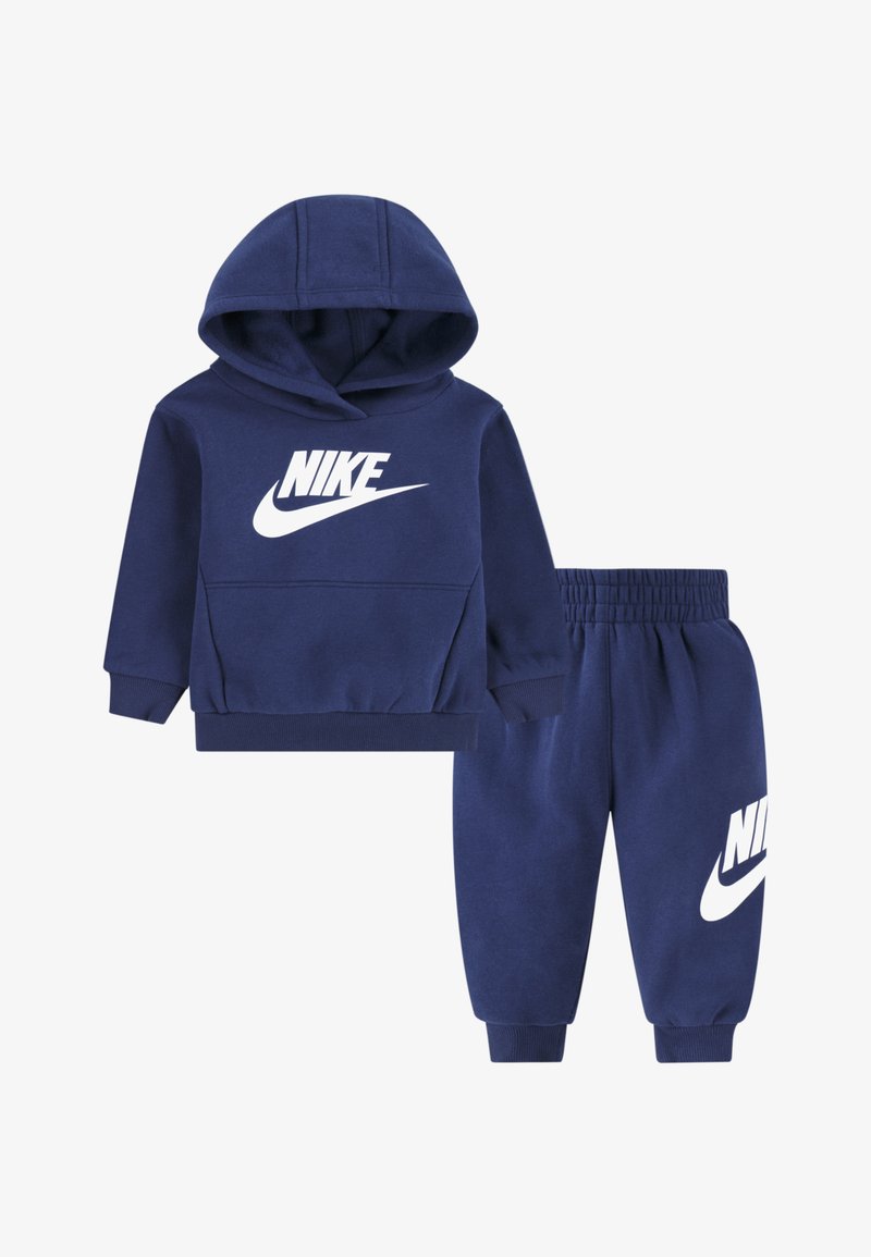 Set temno modre bombažne majice s kapuco in hlač jogger z belim logotipom Nike. Ponaša se s kapuco, rebrastimi manšetami in elastičnim pasom za udobje.