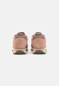 Saucony tenisice od mekog ružičastog suede-a, sa sivim detaljima na peti i logotipu, bež potplatom i teksturiranim donjim dijelom.